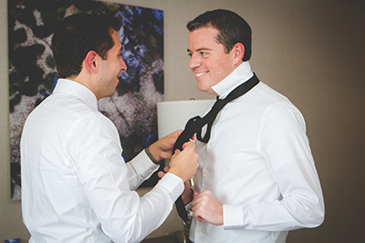 Grooms helping each other tie ties