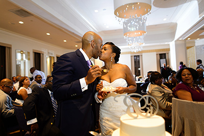 Bride and Groom kissing with cake in front of them