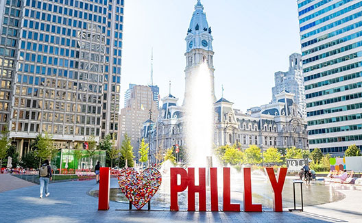 woman with a Phillies jersey holding a beverage